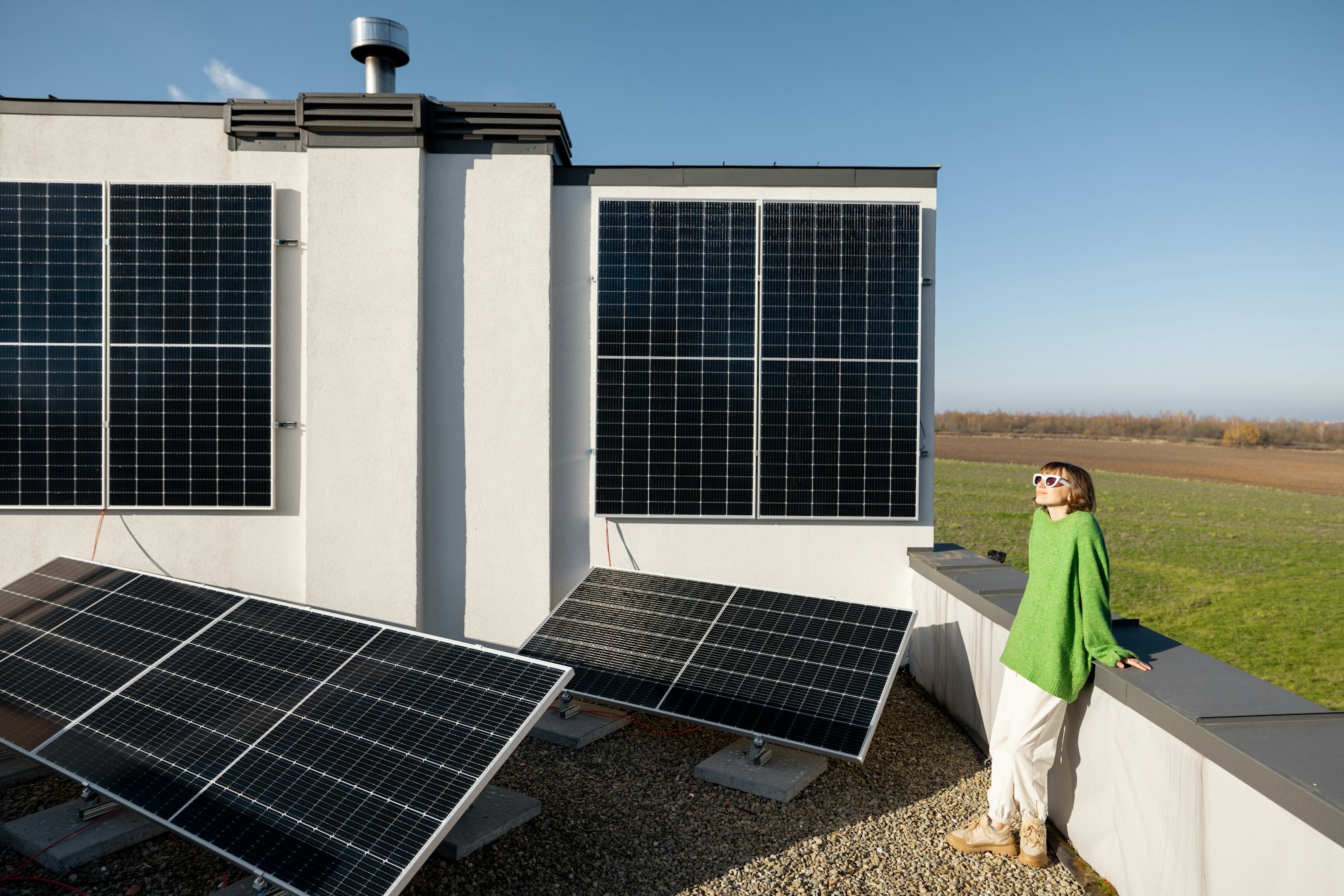 Woman on the roof of her house with a solar station